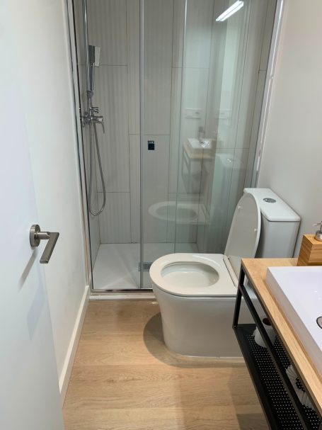 Reforma de baño moderno con plato de ducha y mampara